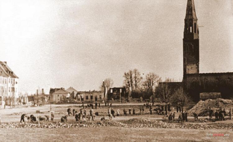 1954 , Naprawa zniszczonej nawierzchni Rynku w Gołdapi. Ruiny południowej pierzei Rynki i Nowego Kościoła. Kościół wkrótce całkowicie zburzono.